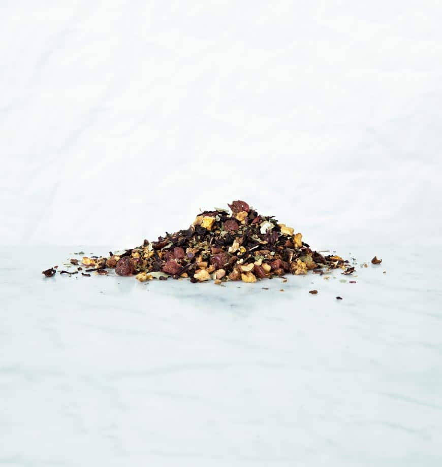 A pile of dried and ground spices on a white surface, including ingredients for Cranberry Eucalyptus tea.