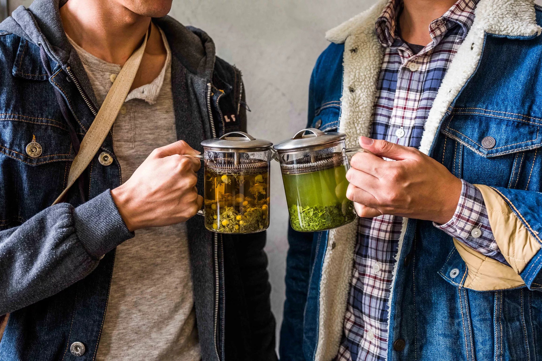 Two people toasting with tea pots