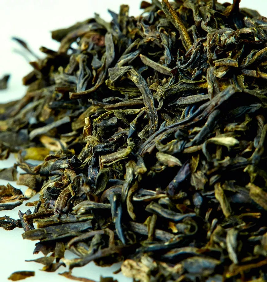 Organic Jasmine Green Tea leaves arranged in a pile on a white background