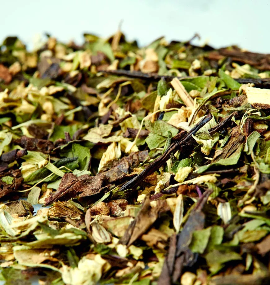 A white surface features a pile of dried Moorish Mint herbs, emphasizing their rich green and brown hues.