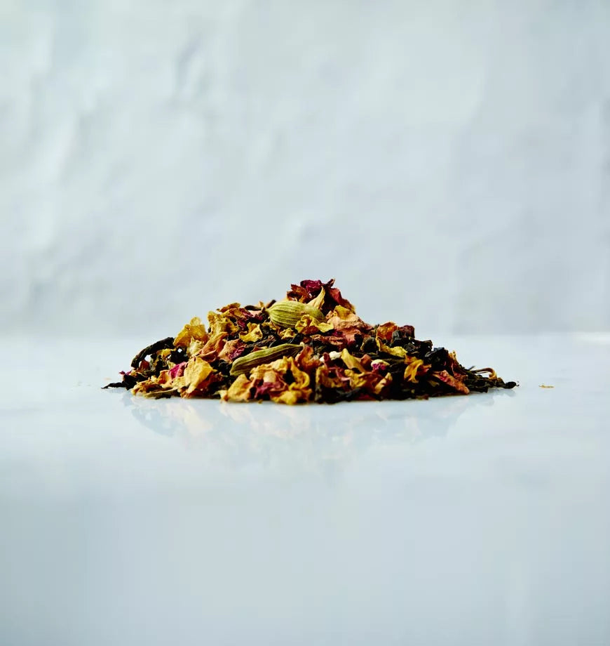 A pile of dried fruit and spices on a white surface, featuring California Persian black tea ingredients.