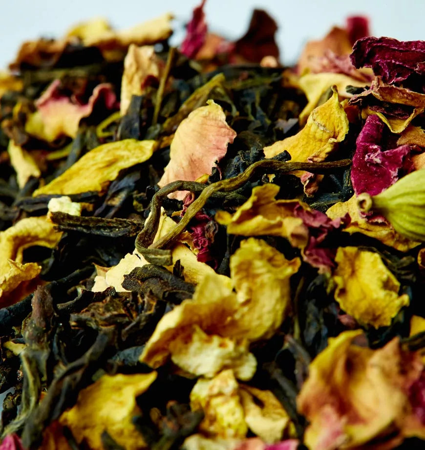 A pile of California Persian tea leaves mixed with colorful flowers, showcasing a blend of natural ingredients.