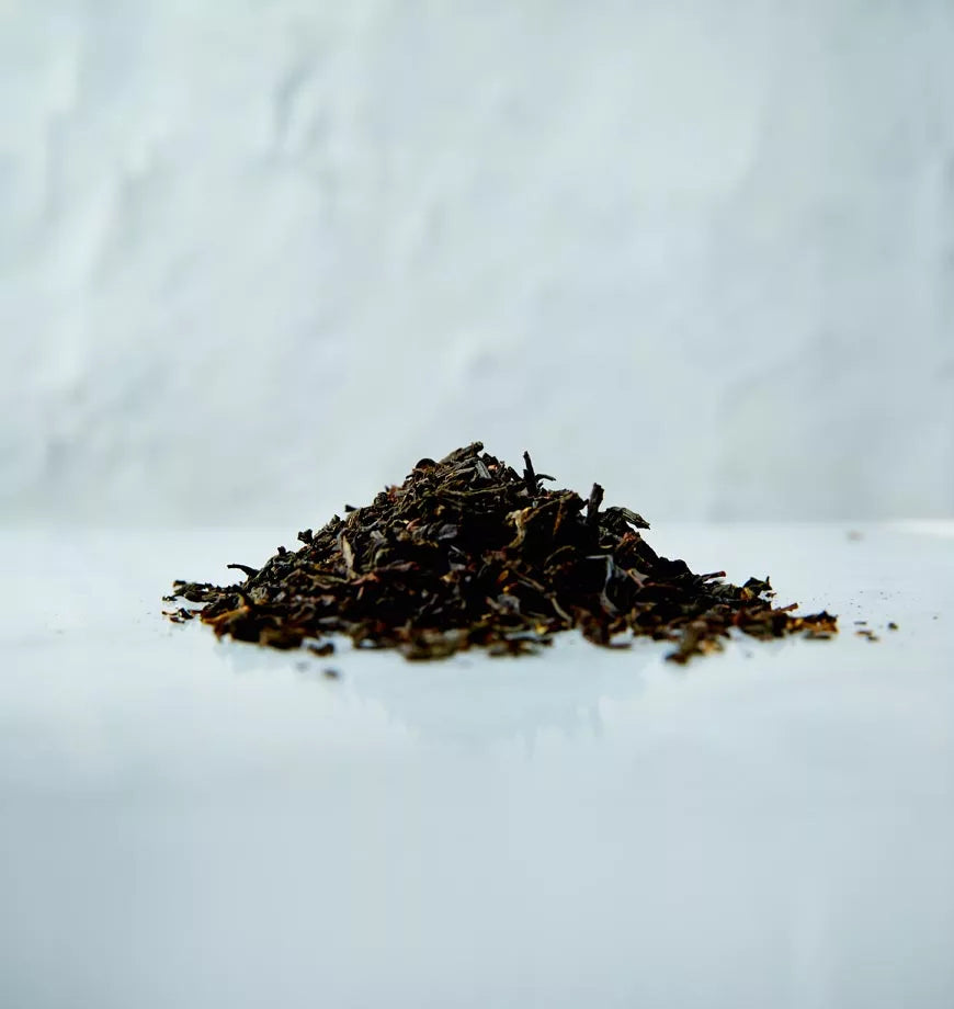 A pile of Earl Grey black tea leaves on a clean white surface.