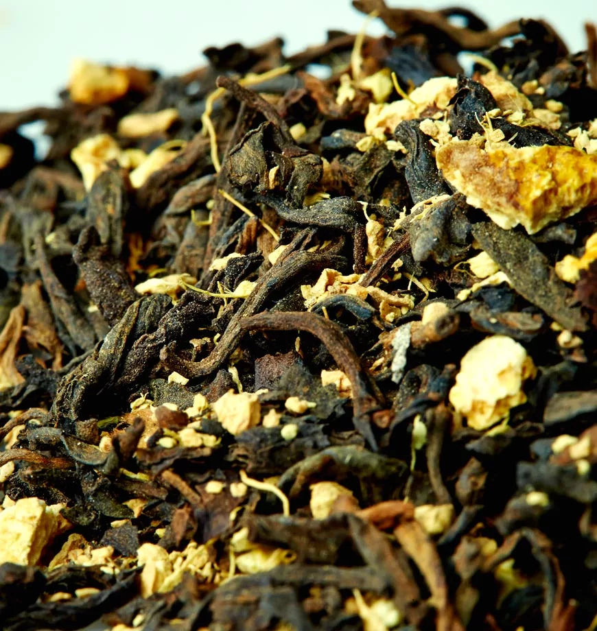 A pile of black tea leaves mixed with dried orange peels, representing Blood Orange Tea.