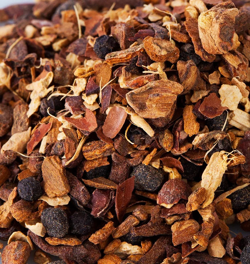 A pile of dried fruit and nuts, showcasing a colorful assortment, with a label for Dandelion Detox herbal infusion nearby.