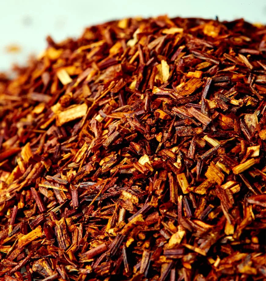 A white bowl filled with a pile of dried red rue, showcasing its vibrant color and texture.
