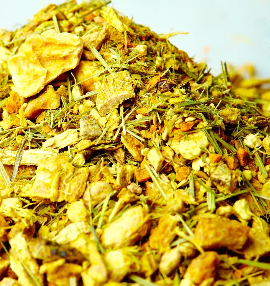A collection of dried herbs and spices, prominently featuring turmeric, displayed on a rustic table surface.