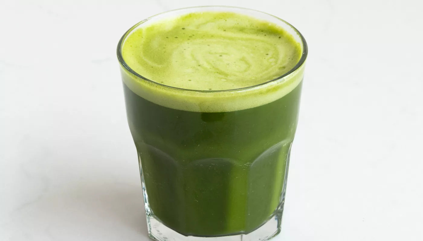 A glass of green matcha on a white surface, labeled as Matcha Hekisui, Japanese matcha tea.