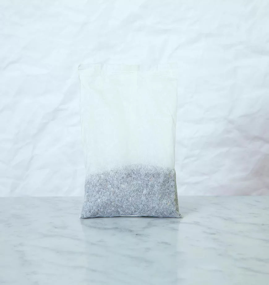 A bag of lavender sits on a table alongside organic black tea bags for Black Iced Tea.