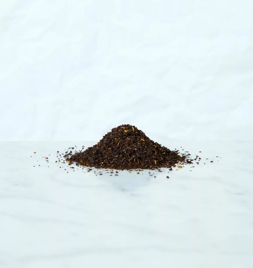 A pile of loose black tea leaves on a clean white surface, suggesting a focus on Black Iced Tea preparation.
